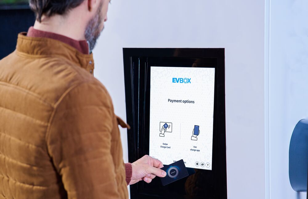 Man using card to pay at a EVBox charging station.