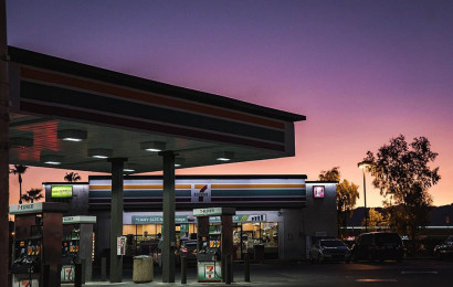 An empty gas station with a convenience store during sunset.