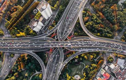 An aerial shot of an intersection of roads in a busy urban environment.