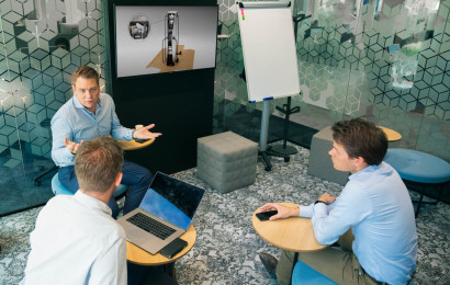 Drei Männer sitzen in einem Büro und reden miteinander