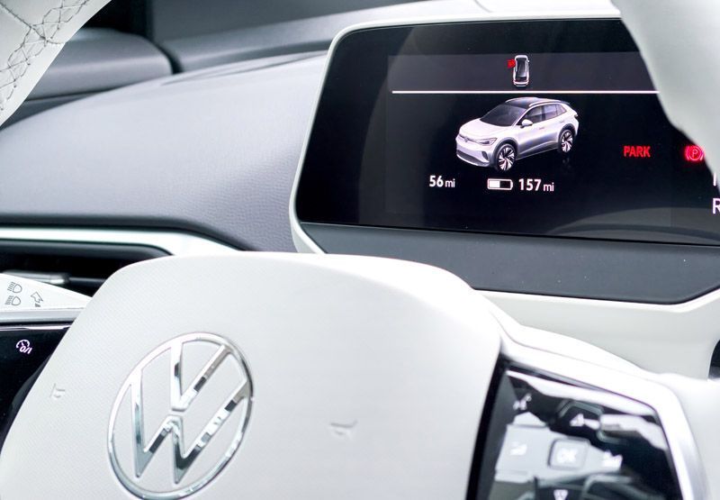 The dashboard of an Electric Volkswagen vehicle indicates that the car is parked, the left-front door is open, the journey was 56 miles and the estimated distance to empty is 157 miles.