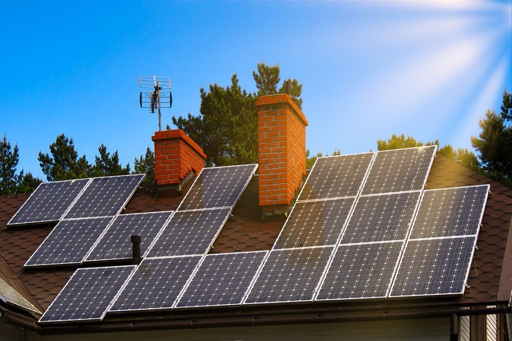 A roof of a home equipped with solar panels during a sunny day.