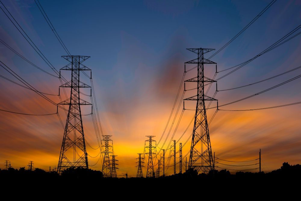 Electrical towers are pictured side to side in the sunset.