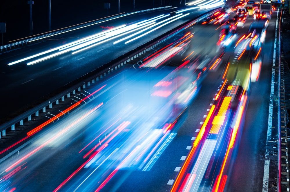 Blurred cars going at fast speed on a highway.