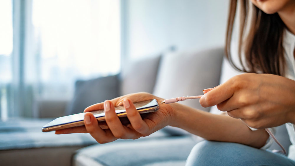 A woman is charging her smartphone.