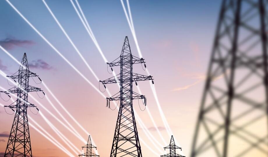 An expansive electrical grid connection featuring towering high-voltage power lines stretching across a rural landscape.