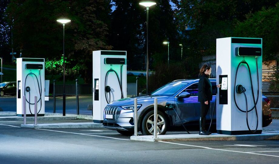 A woman is using EVBox Troniq Modular Level 3 fast charger (DC) to charge her car.