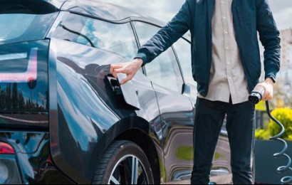 Man charging electric vehicle