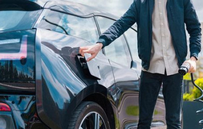 Man charging electric vehicle