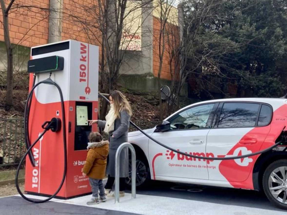 A woman plugging an EVBox charging station cable into her EV