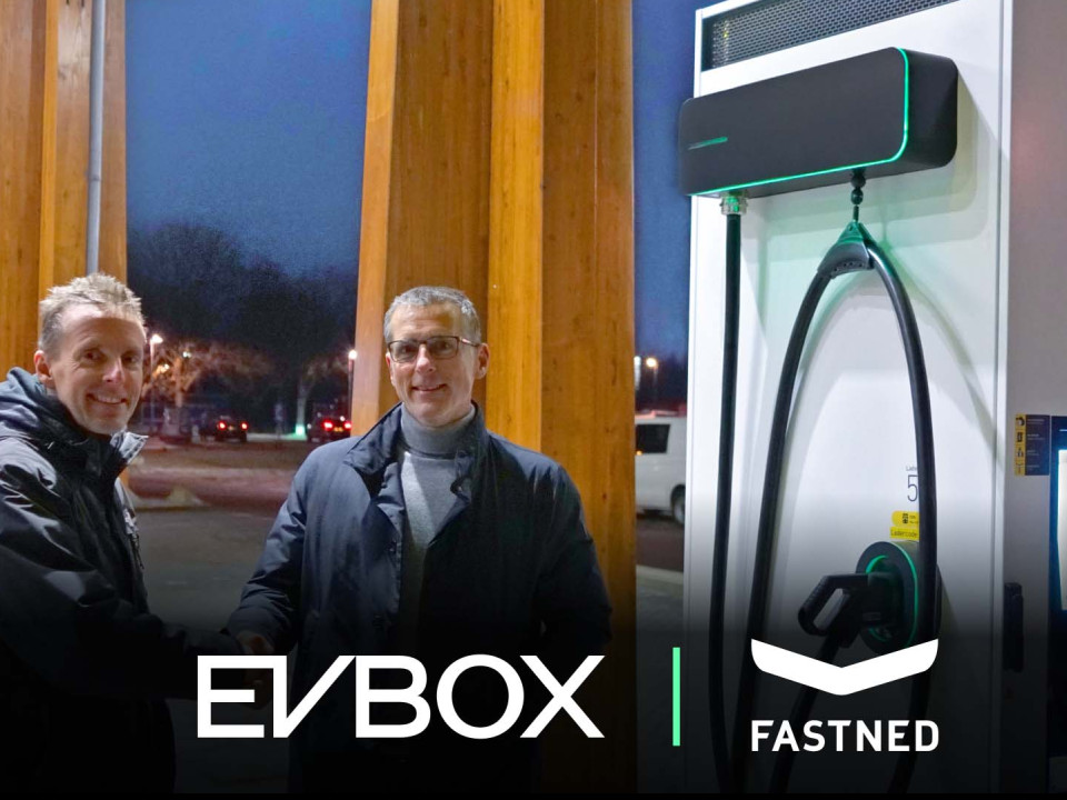 deux hommes se serrant la main devant une station de recharge EVBox