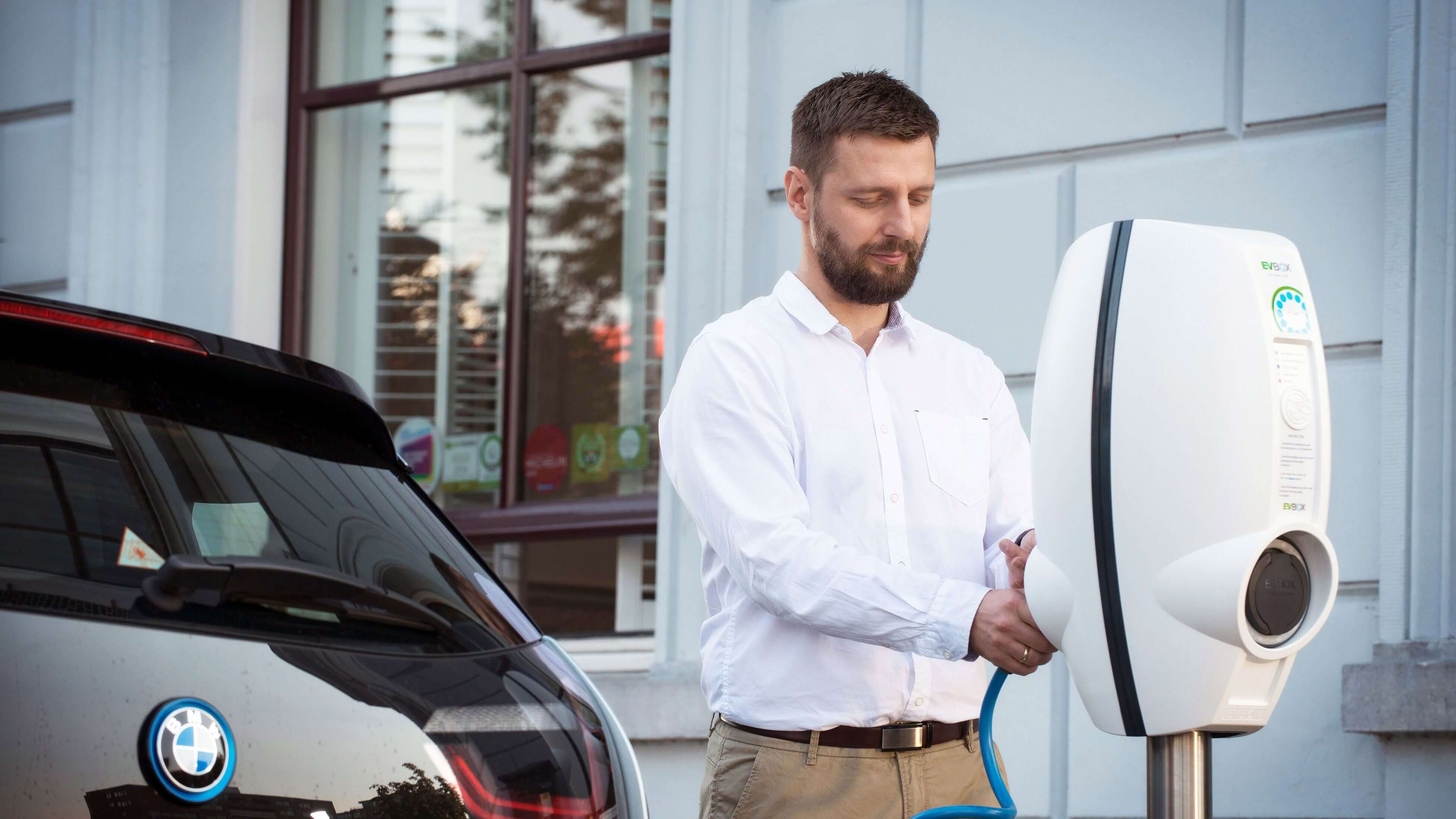 man laadt elektrische auto bmw i3 op met EVBox BusinessLine in het openbaar