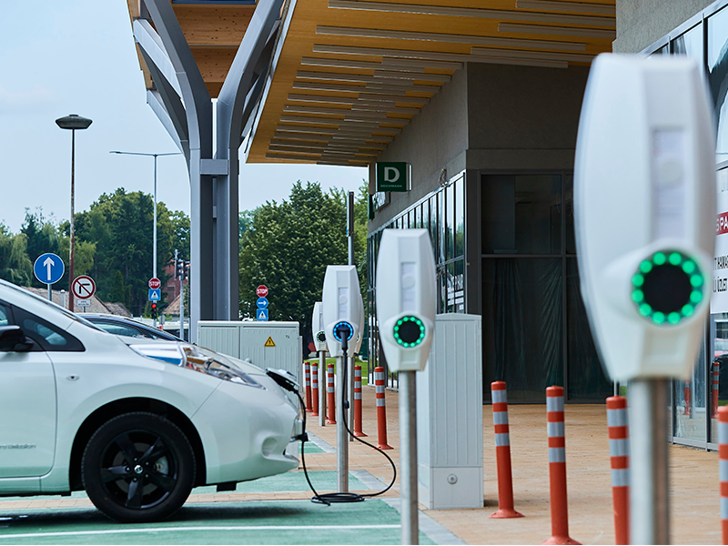 witte nissan leaf geparkeerd naast supermarkt aan het laden bij een EVBox BusinessLine